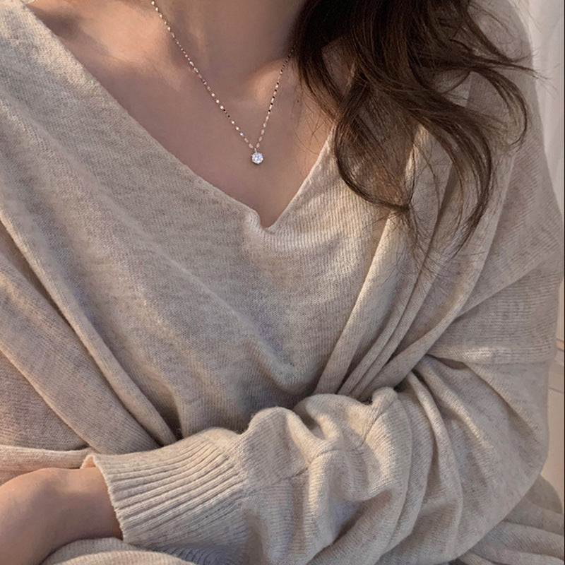 Silver necklace worn on model with beige sweater