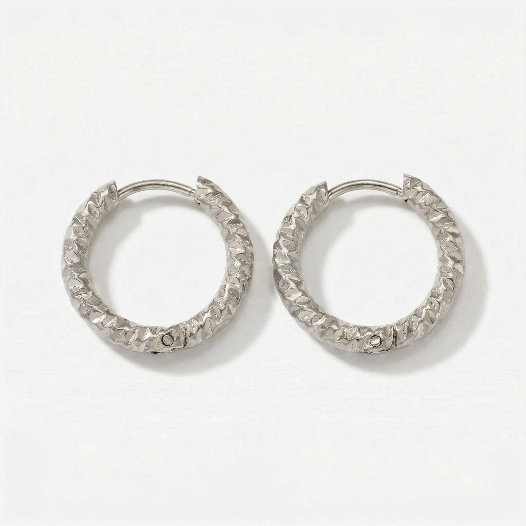 Top-down view of hammered silver hoops