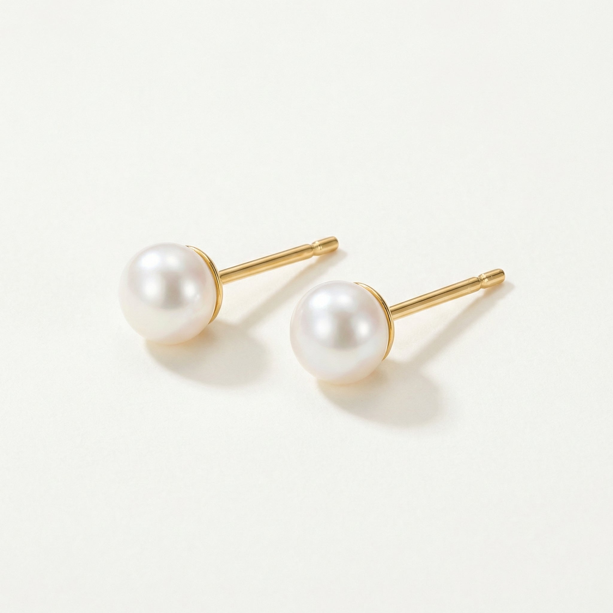 Gold-plated pearl studs, top-down