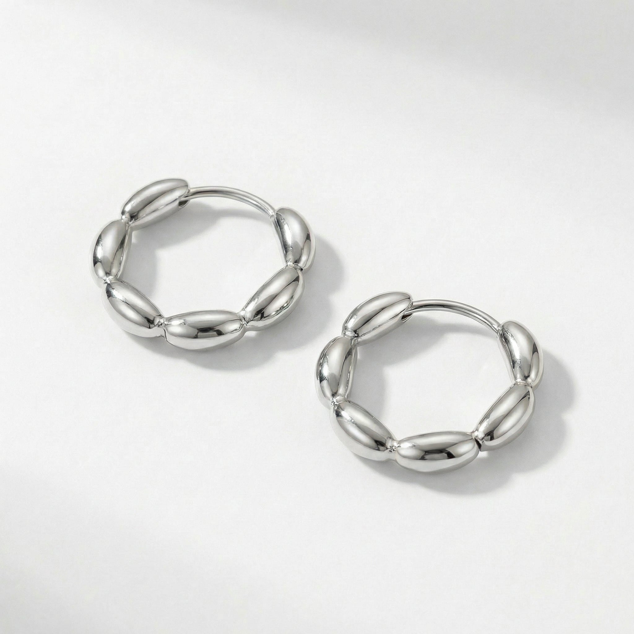 Top-down view of silver huggie hoops