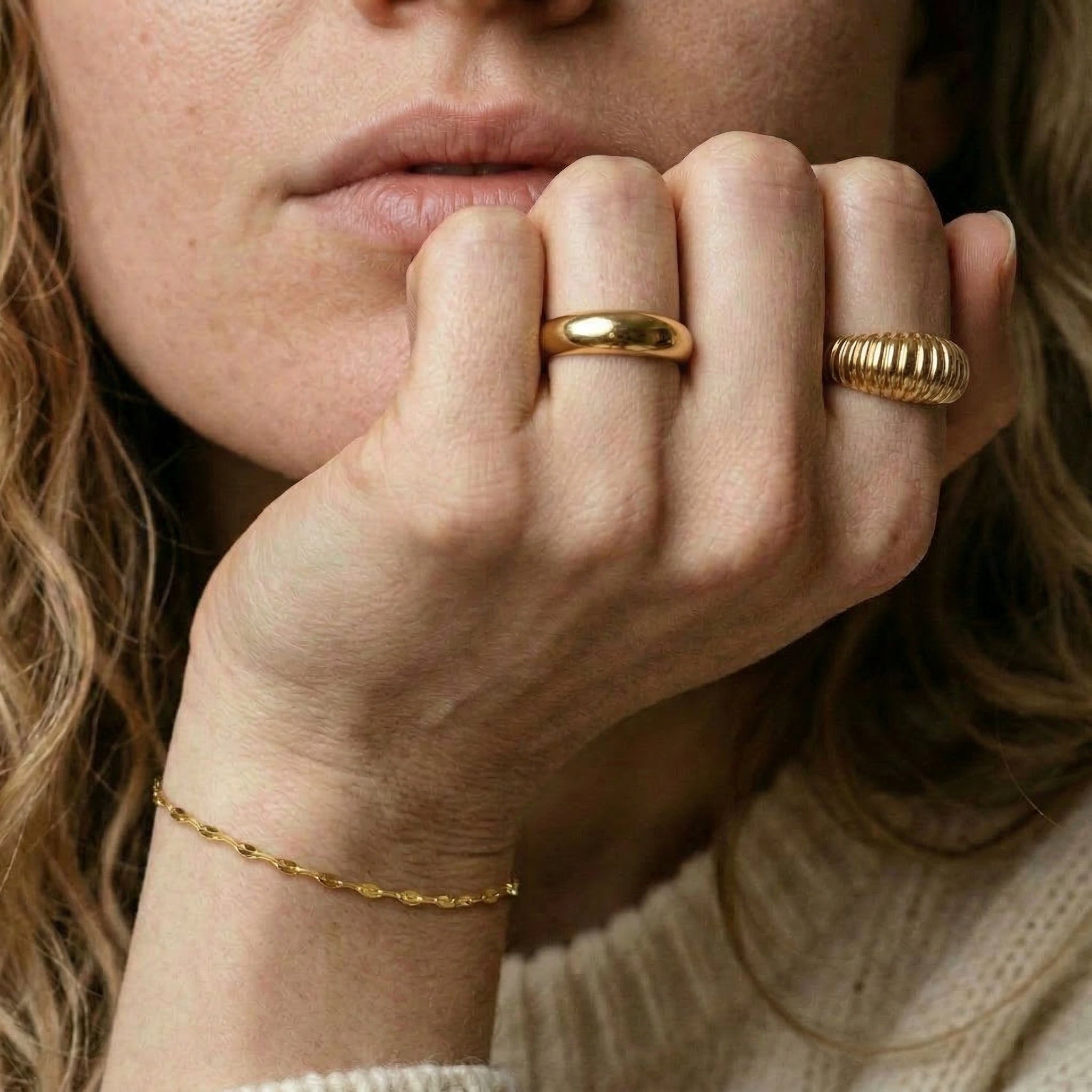 Gold-plated ring worn on hand with other rings