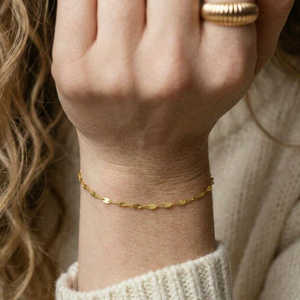 Gold-plated bracelet on wrist with ring