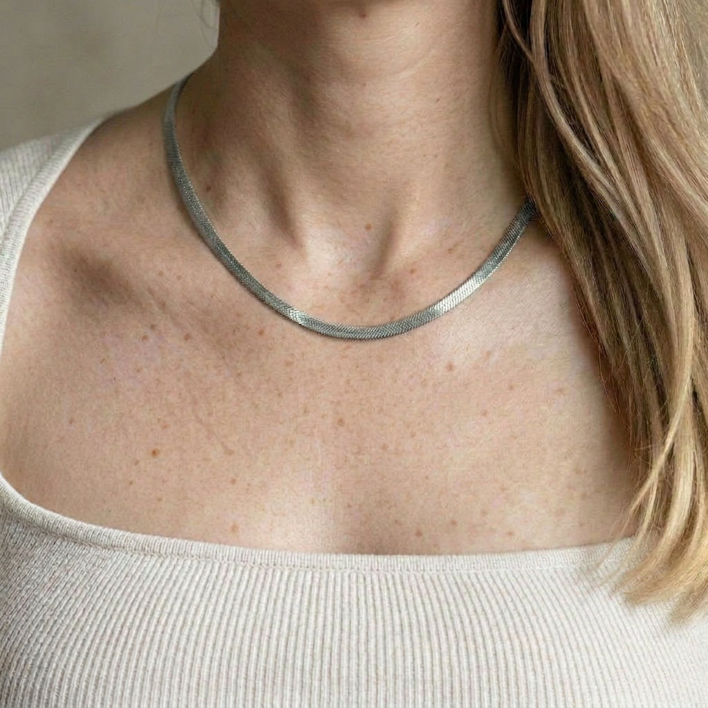 Silver necklace on model with white top