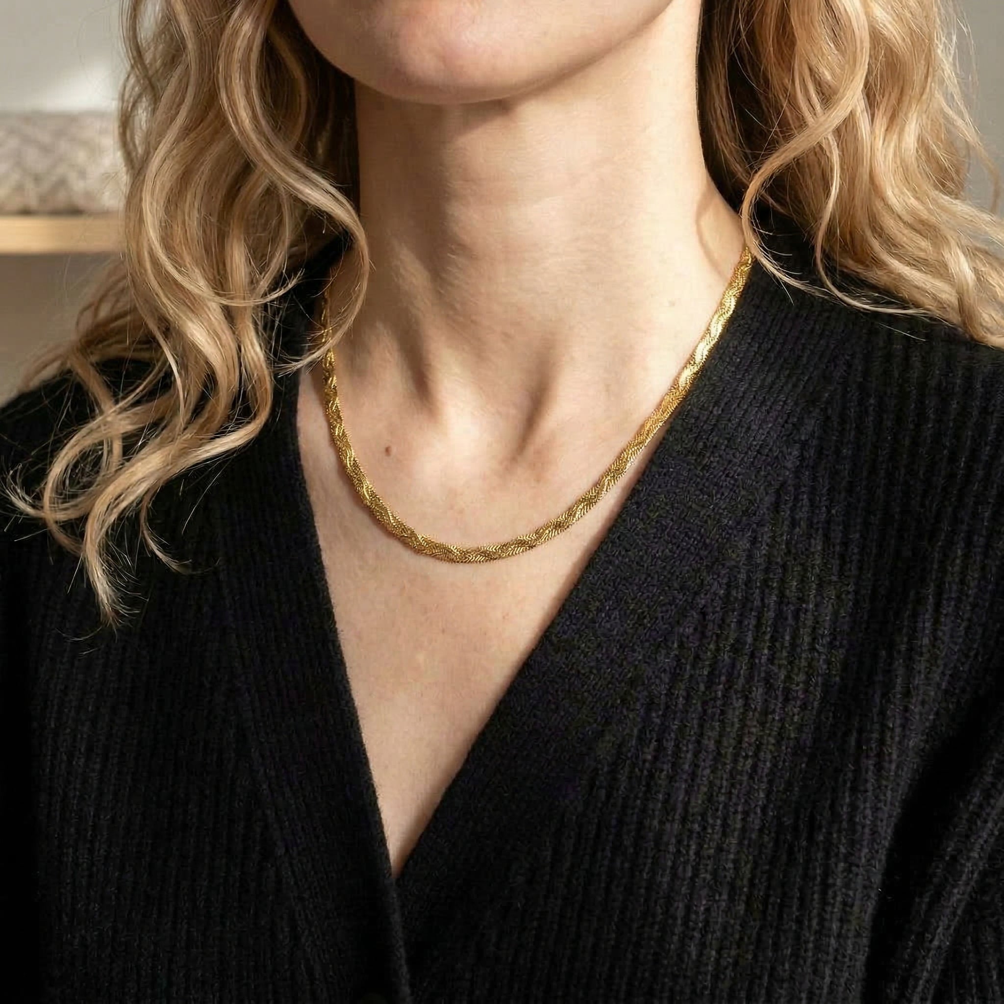 Gold-plated necklace worn with black cardigan