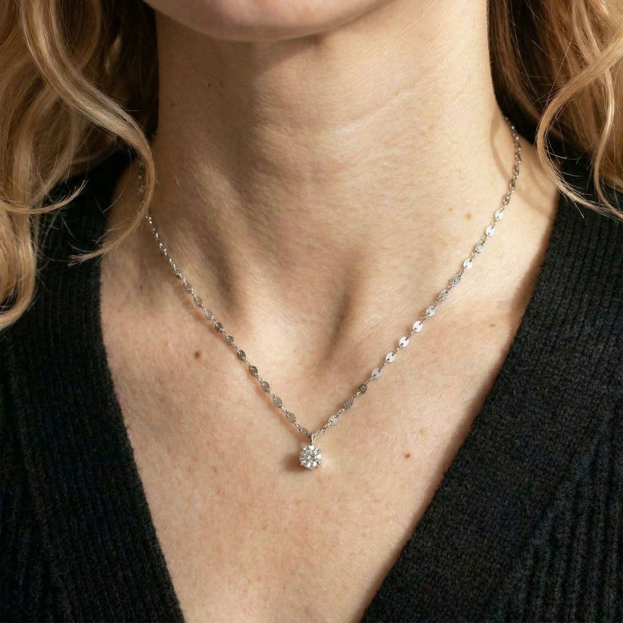Silver necklace worn on model with black top