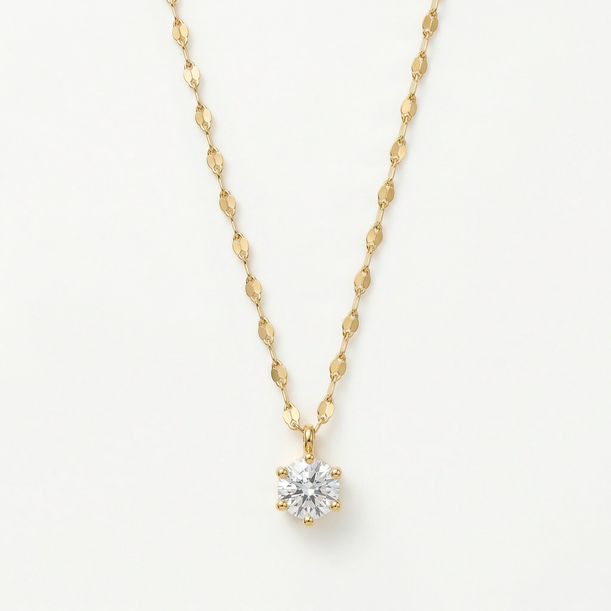 Gold-plated solitaire necklace on white background