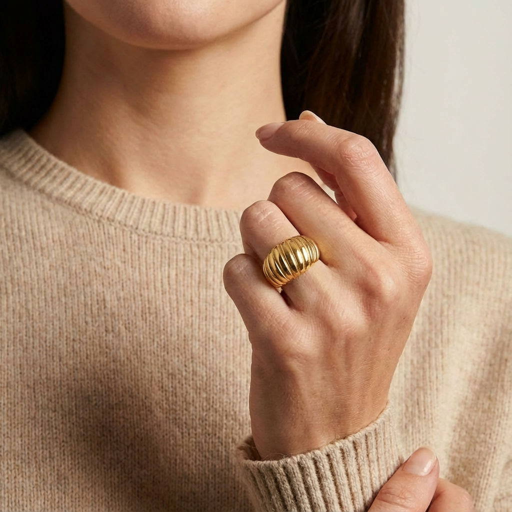 Gold-plated ring worn on hand with sweater