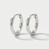 Pair of matte silver hoop earrings with a brushed finish, casting soft shadows on a white background.