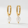 Pair of gold hoop earrings with white baroque pearl drops, each pearl capped with a small gold bead.