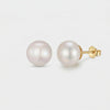 Pair of round white pearl stud earrings with gold-toned posts and butterfly backs.