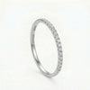 Silver band ring with a row of small, round, clear gemstones across the top half.