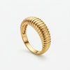 Gold ring with a ribbed, textured band, angled on a white background.