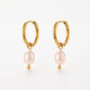Pair of gold hoop earrings with dangling baroque pearls, each pearl ending with a small gold bead.