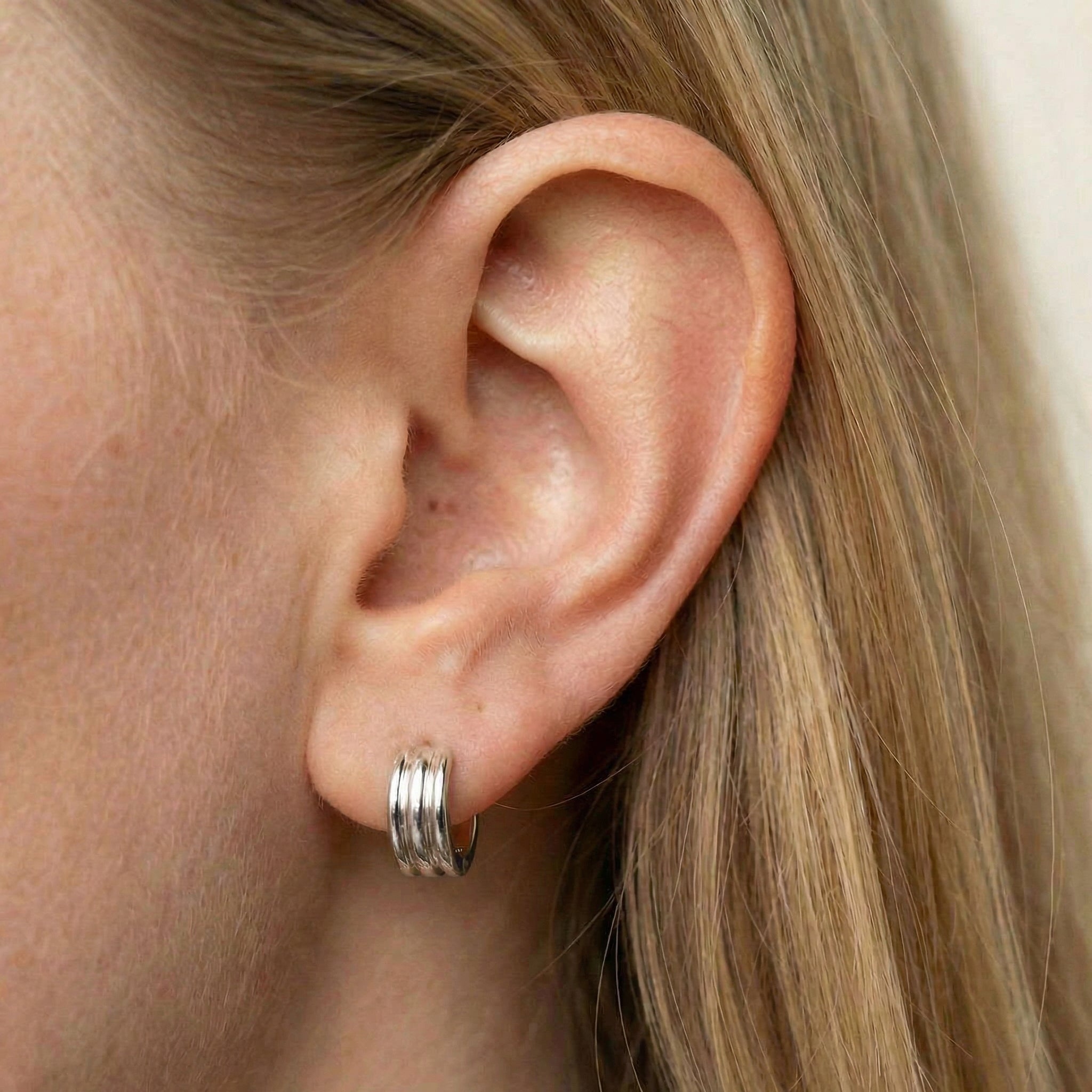 Hoop earrings silver earring worn on ear with blonde hair