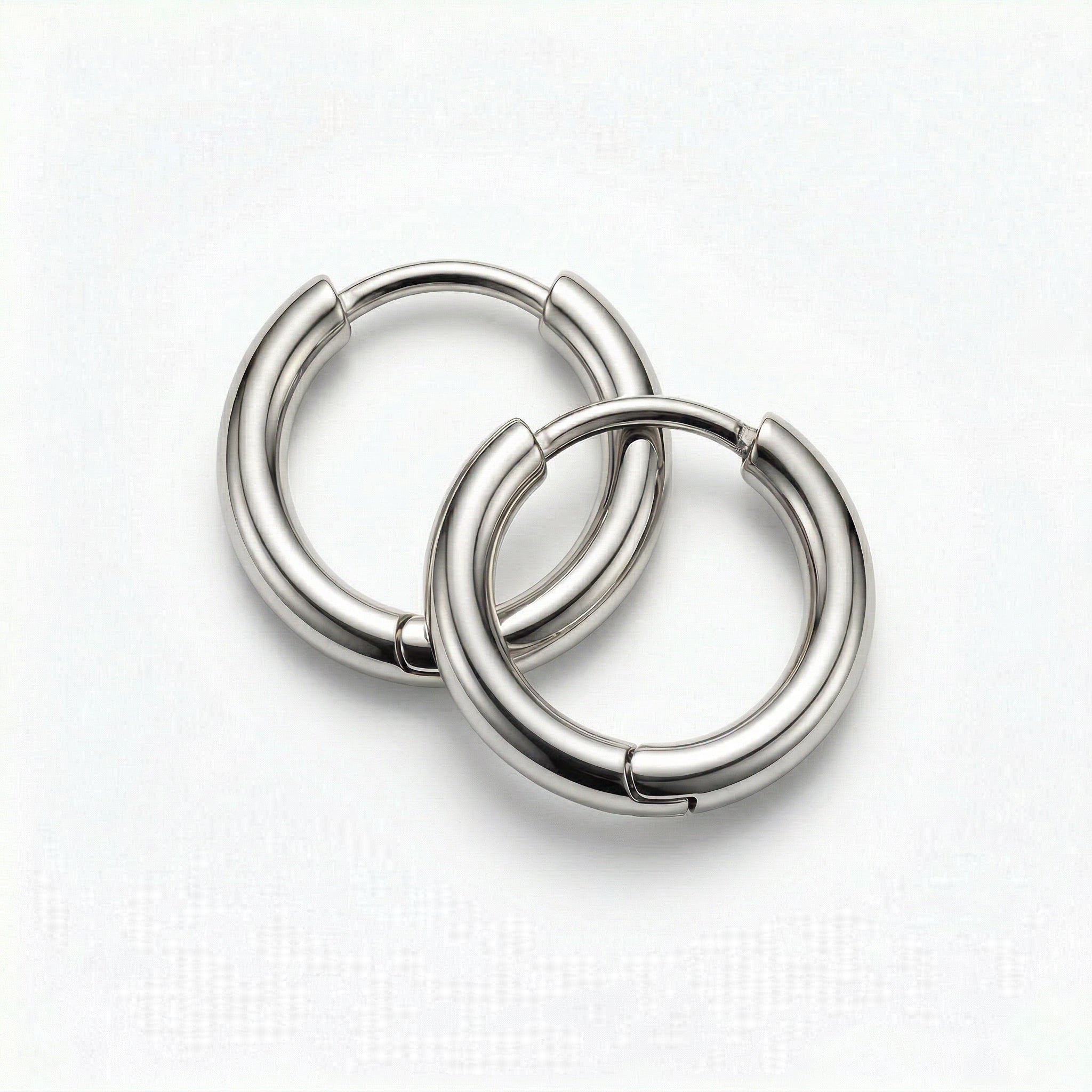 Two silver hoops interlocked on white background