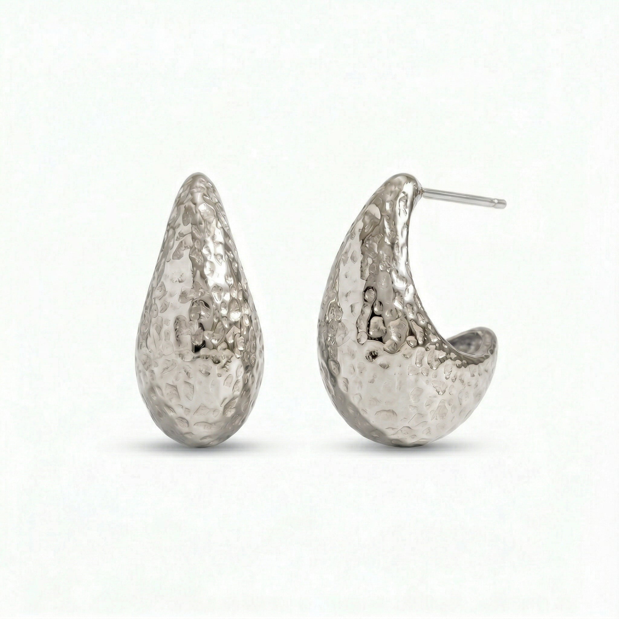 Silver hammered hoop earrings on white background