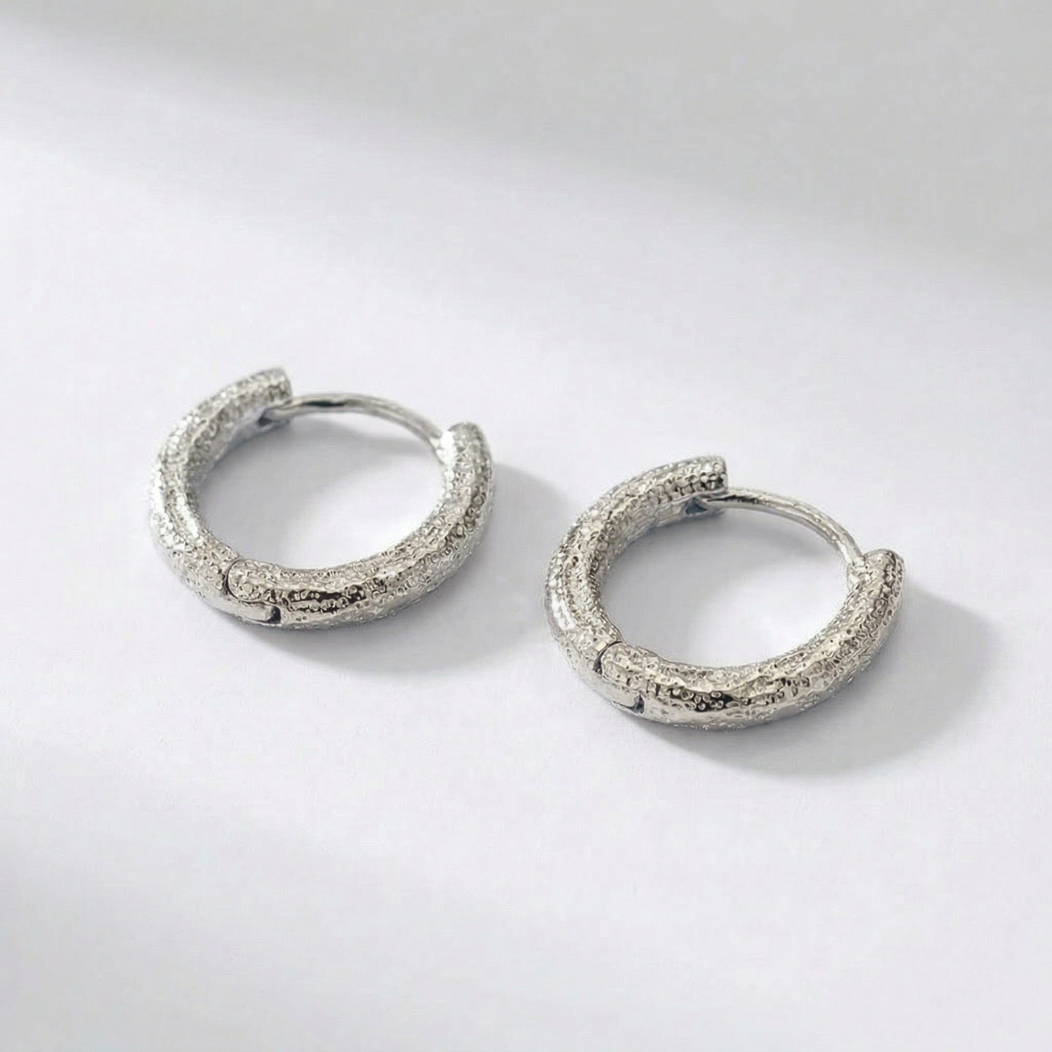 Top-down view of hammered silver hoops