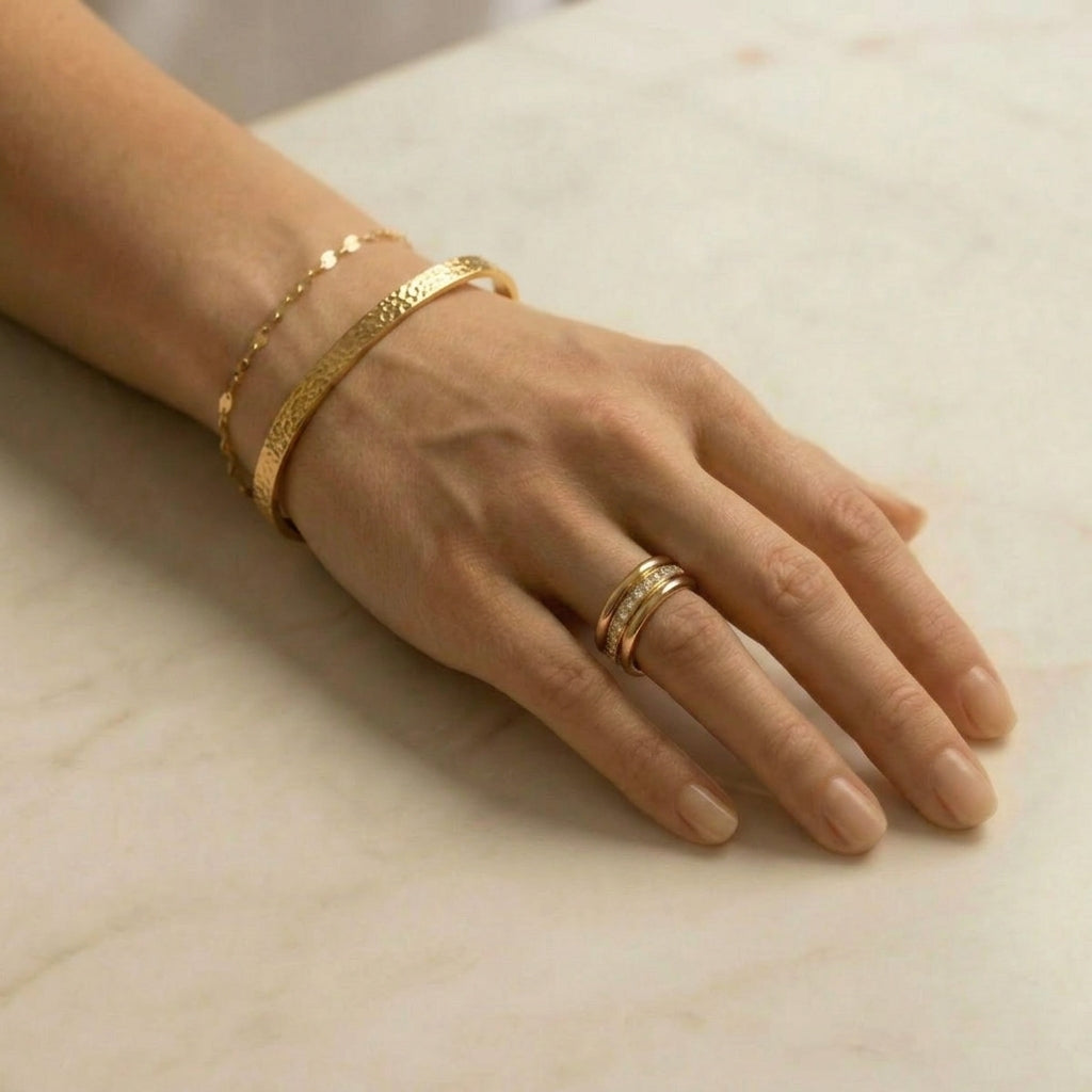 Gold-plated bracelet stacked with other jewelry