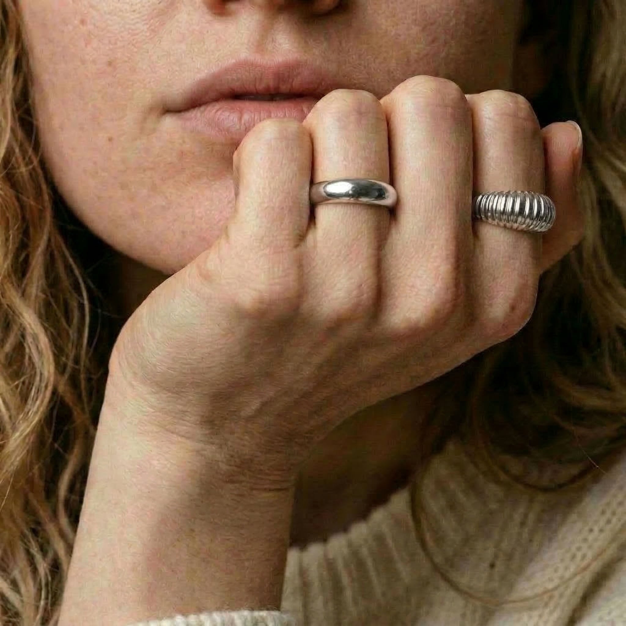 Silver ring worn on hand with another ring