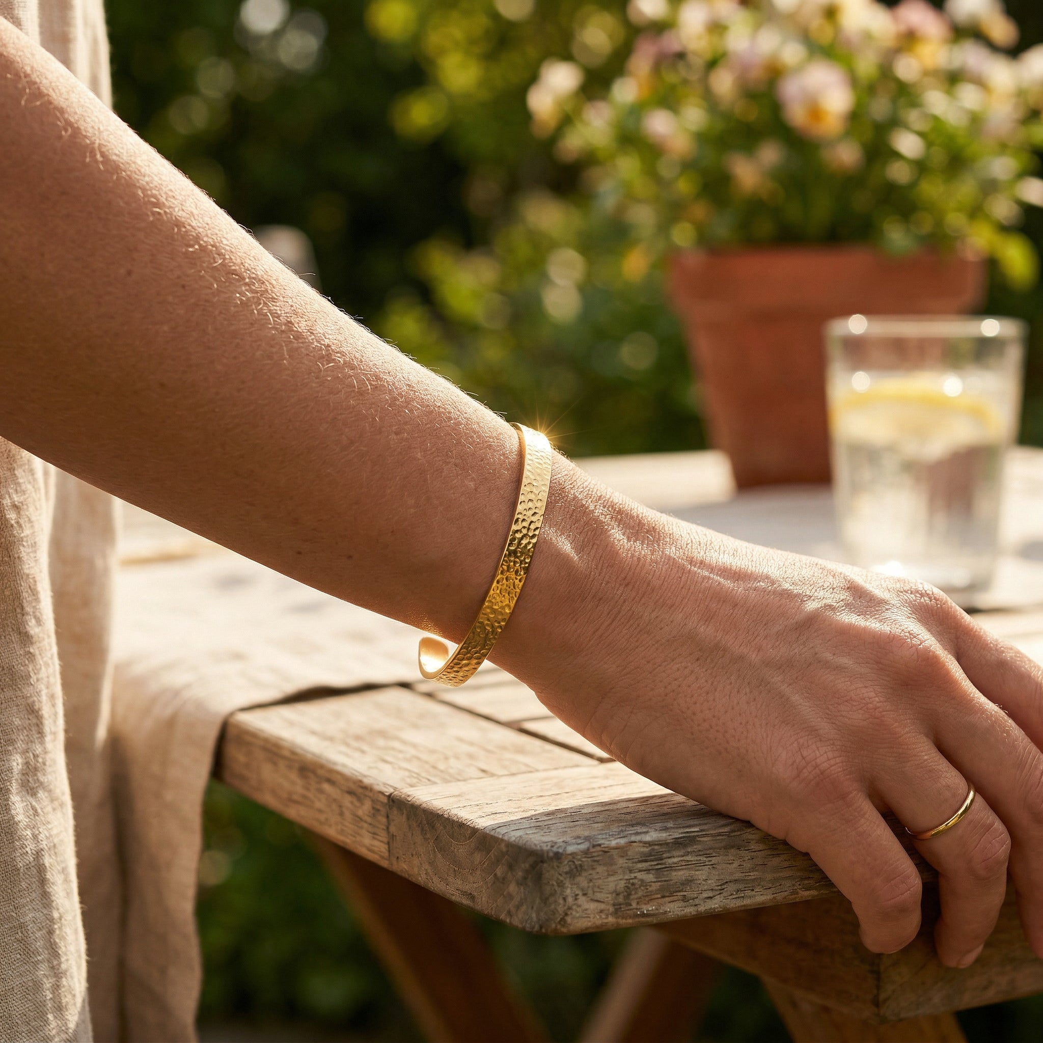 Gold-plated bangle worn on arm outdoors