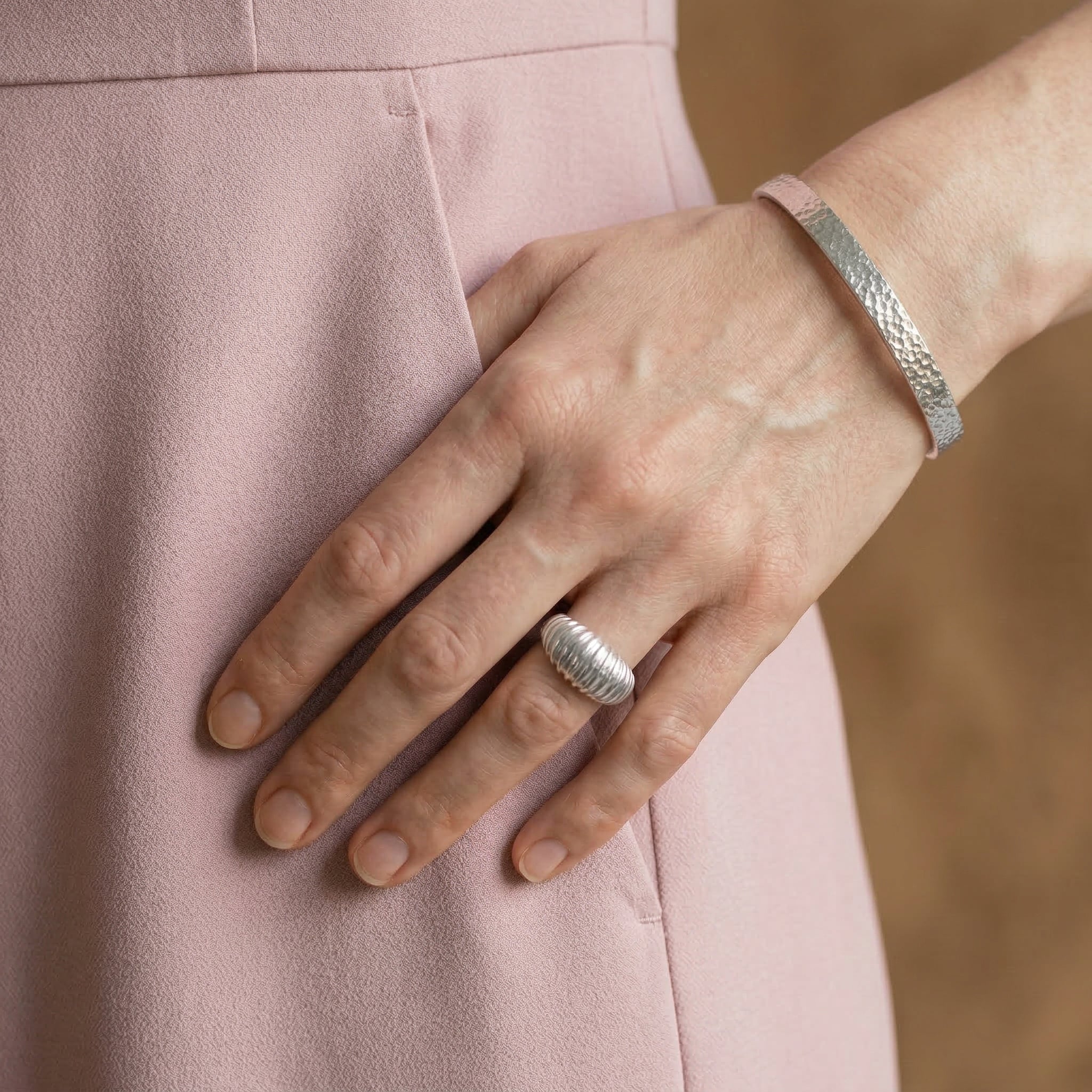 Silver bangle on wrist with pink outfit