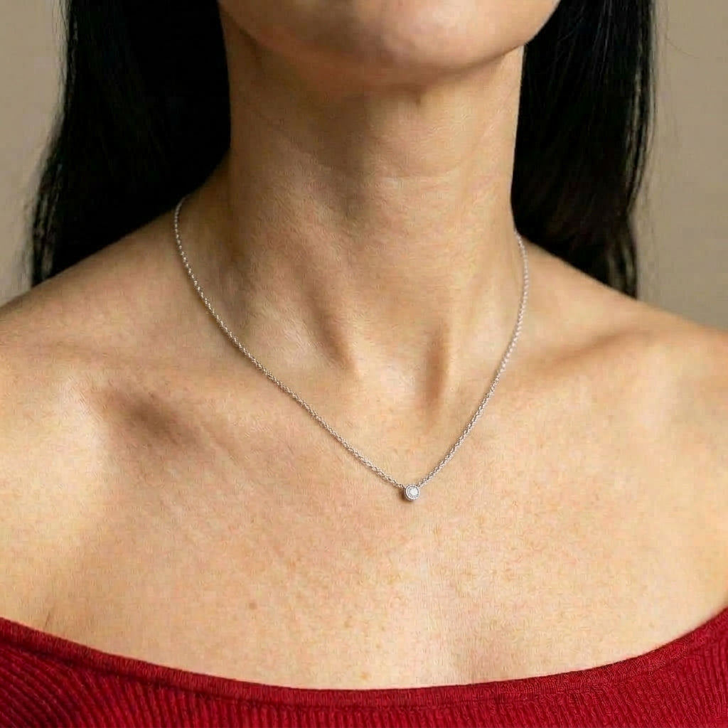 Silver necklace worn on model with red top