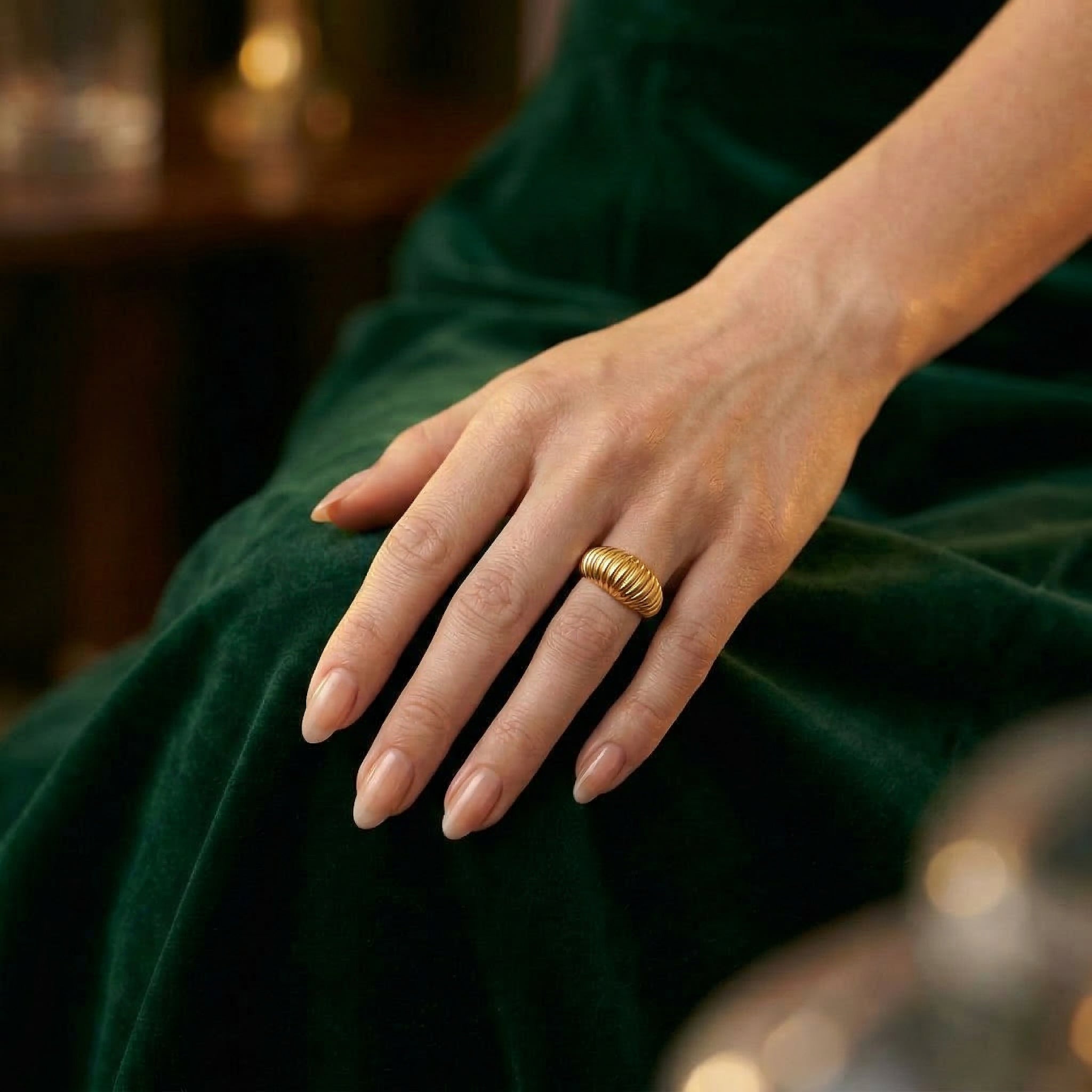 Gold-plated ring worn on hand with green dress