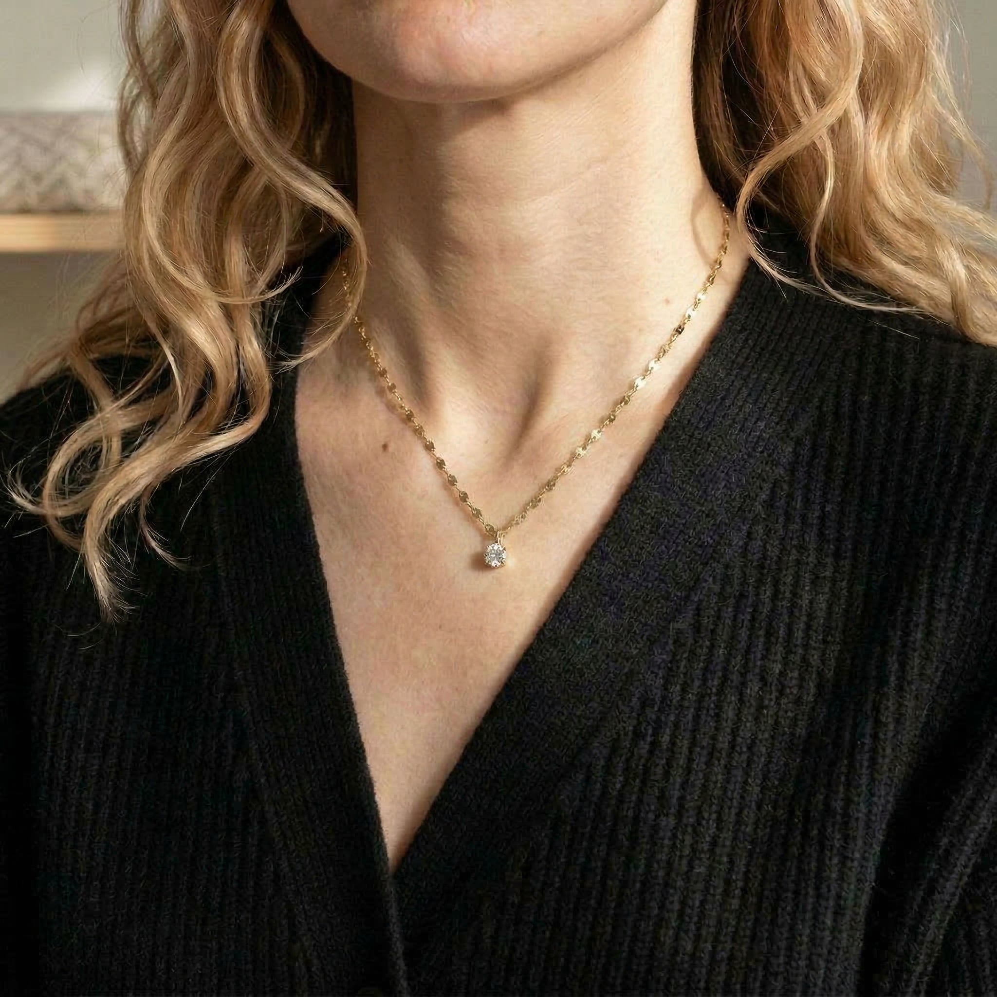 Gold-plated necklace worn with black cardigan
