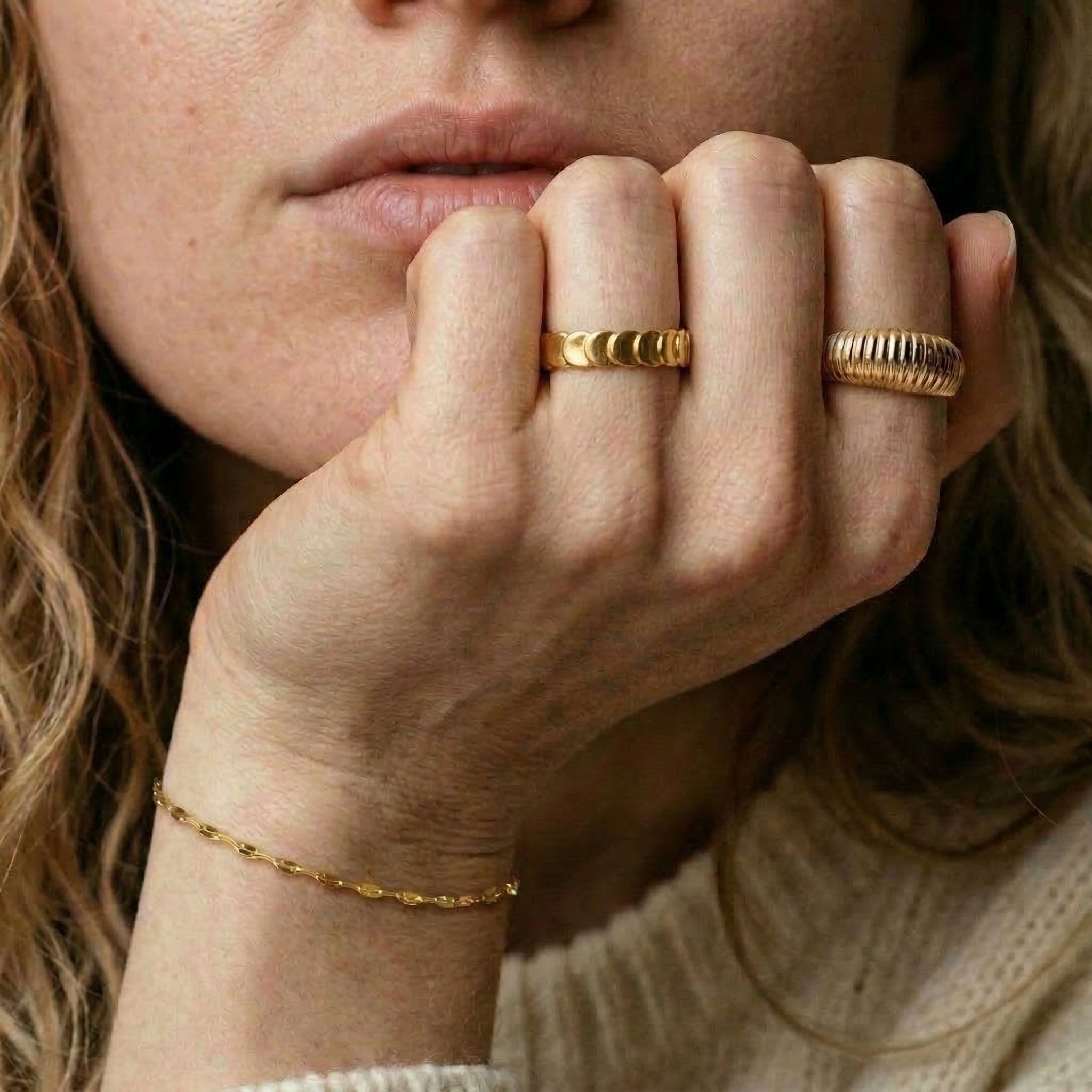 Gold-plated ring worn on hand with other rings