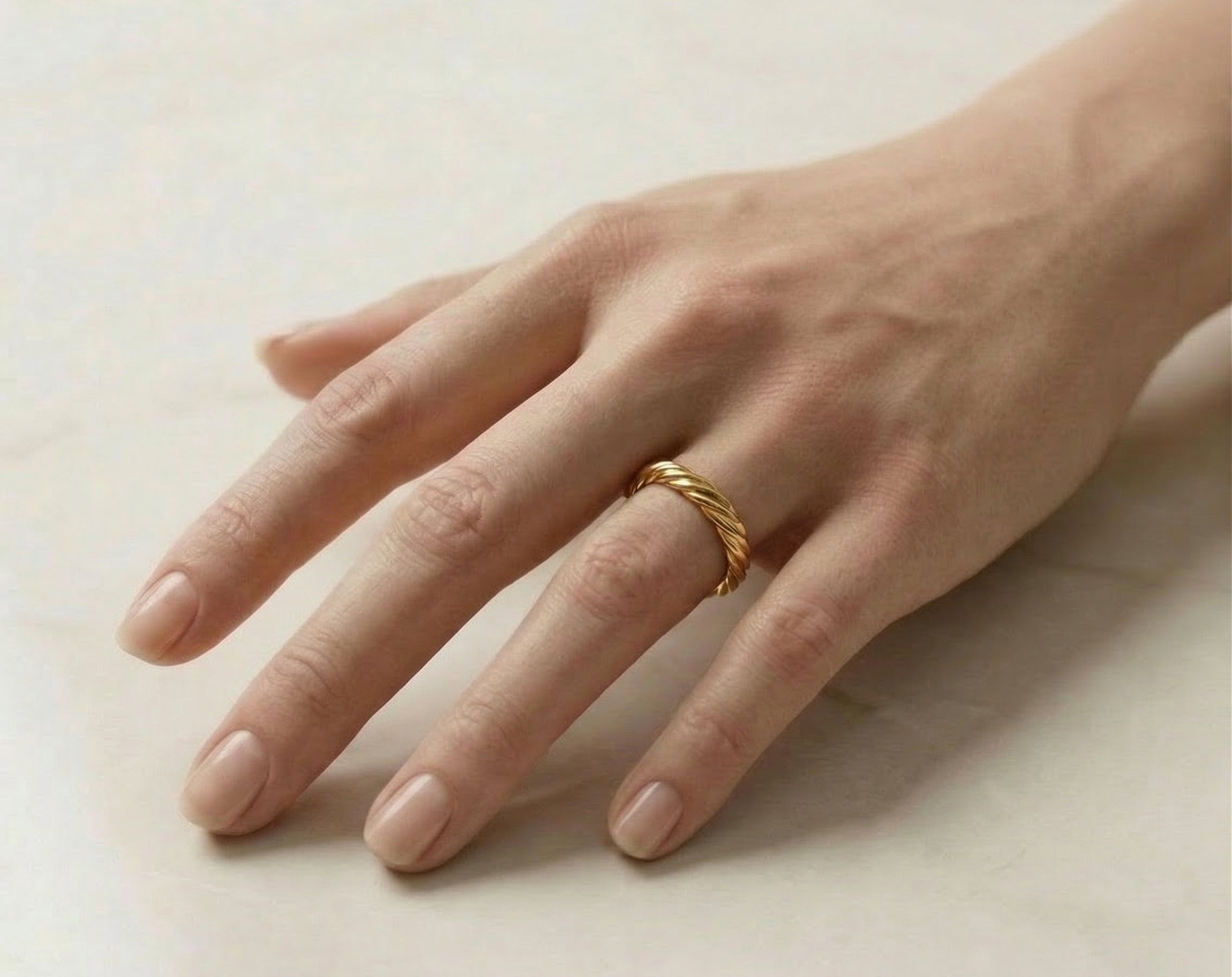 Gold-plated ring on model's hand, top view